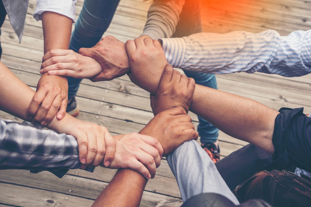 People holding hands to illustrate teamwork